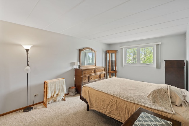 bedroom featuring light carpet and baseboards