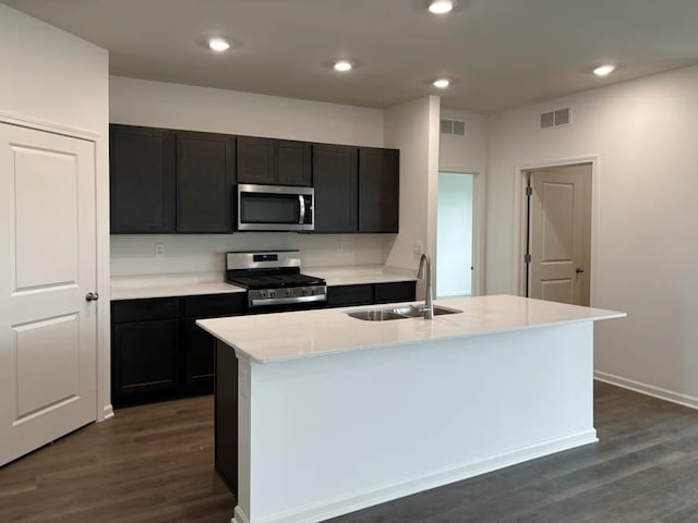 kitchen featuring stainless steel appliances, a sink, dark wood-style floors, recessed lighting, and light countertops
