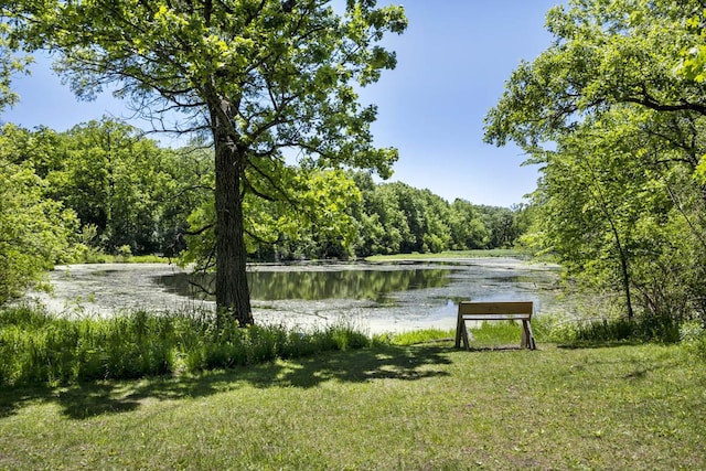 surrounding community with a wooded view, a water view, and a yard
