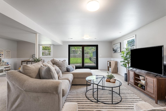 living room with light colored carpet and a wainscoted wall