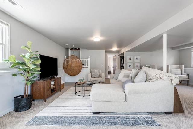 carpeted living area featuring visible vents and baseboards