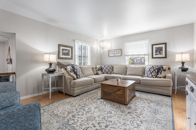 living room featuring baseboards, light wood-style floors, and a healthy amount of sunlight