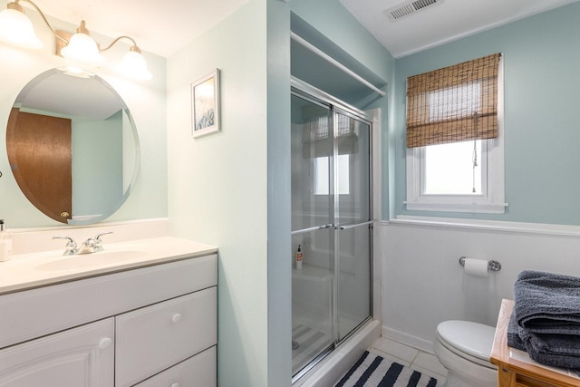 bathroom featuring toilet, vanity, visible vents, tile patterned flooring, and a shower stall