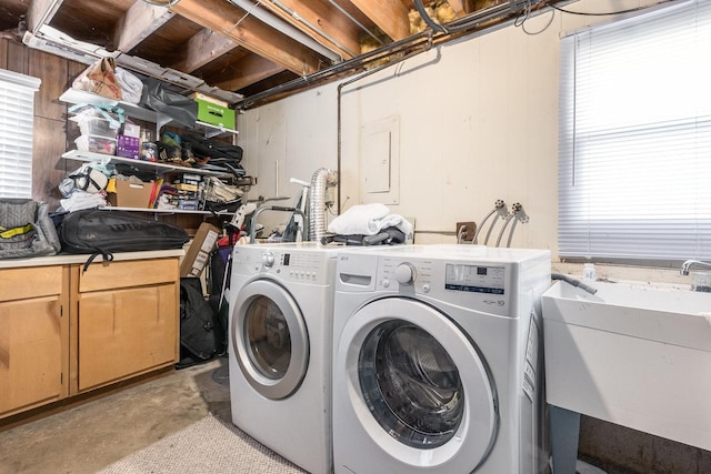 clothes washing area featuring cabinet space, independent washer and dryer, and a sink