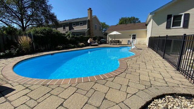 view of swimming pool featuring a patio, a fenced in pool, and a fenced backyard