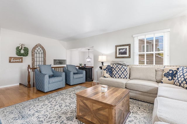 living area with baseboards and wood finished floors