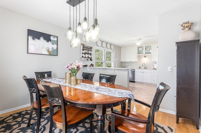 dining area with ceiling fan, baseboards, and light wood-style floors