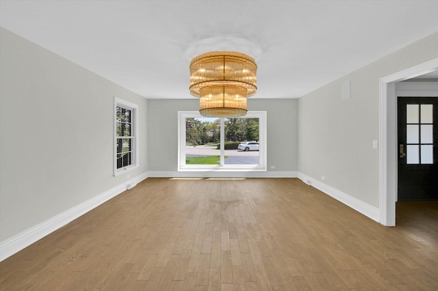 8 Wyndham Ct, Oak Brook, IL 60523 - empty room with wood finished floors, a chandelier, and baseboards