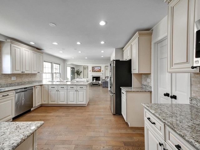 8 Wyndham Ct, Oak Brook, IL 60523 - kitchen with stainless steel appliances, decorative backsplash, open floor plan, light wood-style flooring, and recessed lighting