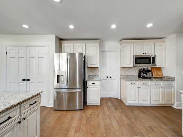 8 Wyndham Ct, Oak Brook, IL 60523 - kitchen featuring stainless steel appliances, light wood-style flooring, tasteful backsplash, light stone counters, and recessed lighting