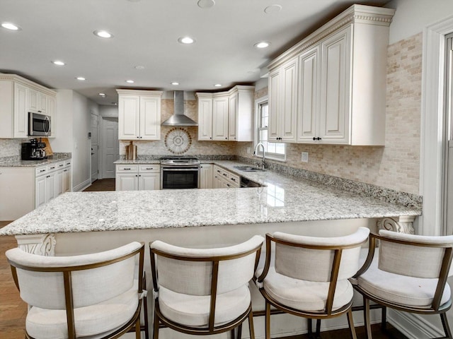8 Wyndham Ct, Oak Brook, IL 60523 - kitchen with stainless steel appliances, a sink, wall chimney range hood, a peninsula, and backsplash