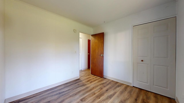 3320 Kimberly Dr, Champaign, IL 61821 - unfurnished bedroom featuring wood finished floors, baseboards, a closet, and crown molding
