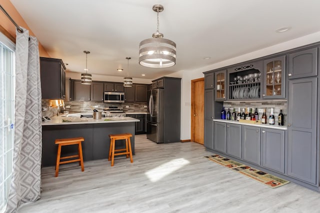 18034 Donatus Dr, Lansing, IL 60438 - kitchen featuring backsplash, light wood finished floors, a peninsula, and appliances with stainless steel finishes