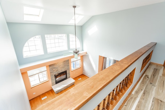 18034 Donatus Dr, Lansing, IL 60438 - staircase featuring a skylight, wood finished floors, high vaulted ceiling, and a stone fireplace