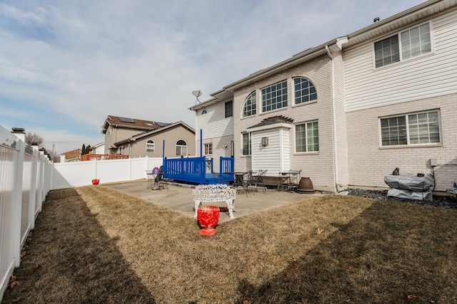 18034 Donatus Dr, Lansing, IL 60438 - rear view of house with a fenced backyard, a patio area, a yard, and brick siding