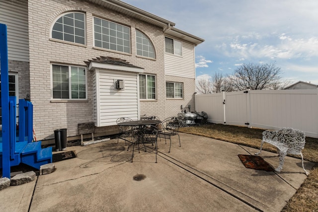 18034 Donatus Dr, Lansing, IL 60438 - rear view of property with outdoor dining space, brick siding, a patio area, a fenced backyard, and a gate