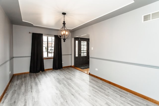 18034 Donatus Dr, Lansing, IL 60438 - spare room with wood finished floors, visible vents, a chandelier, a tray ceiling, and baseboards