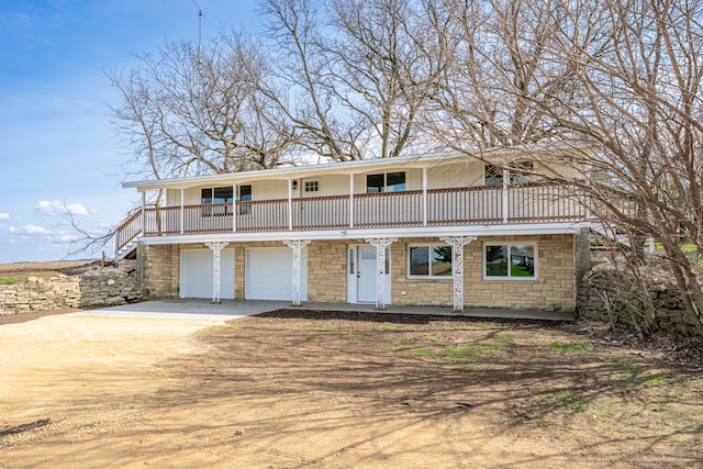 237 N Simmons St, Stockton, IL 61085 - view of front facade with an attached garage, stone siding, concrete driveway, stairway, and a porch