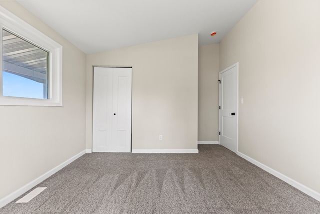 237 N Simmons St, Stockton, IL 61085 - unfurnished bedroom with carpet flooring, a closet, visible vents, baseboards, and lofted ceiling