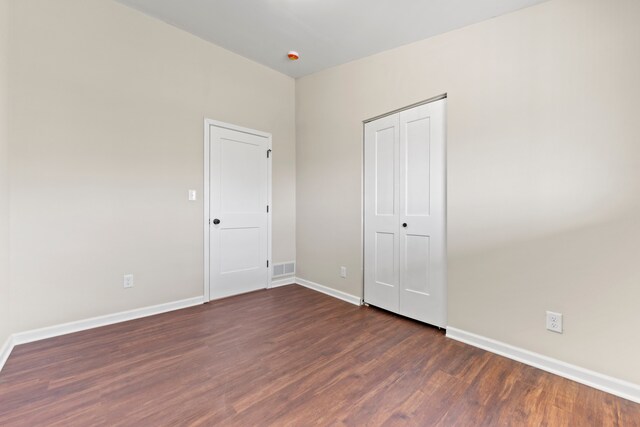 237 N Simmons St, Stockton, IL 61085 - unfurnished bedroom with baseboards, dark wood-style floors, visible vents, and a closet