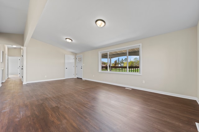 237 N Simmons St, Stockton, IL 61085 - unfurnished living room featuring dark wood-style flooring, baseboards, and lofted ceiling