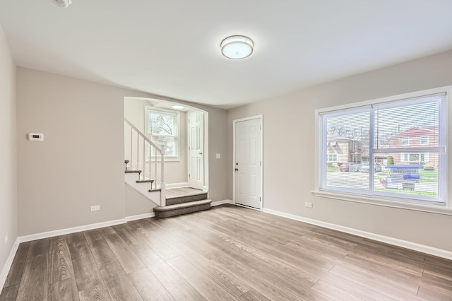 interior space with stairs, baseboards, and wood finished floors