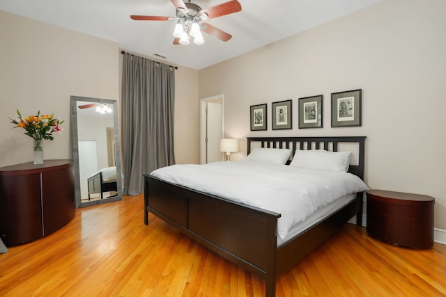 bedroom with ceiling fan, visible vents, and light wood-style floors