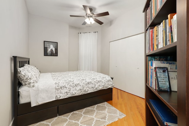 bedroom with ceiling fan, a closet, and wood finished floors