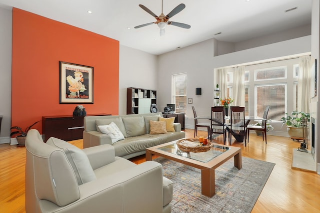 living room featuring light wood-type flooring, visible vents, recessed lighting, a ceiling fan, and baseboards