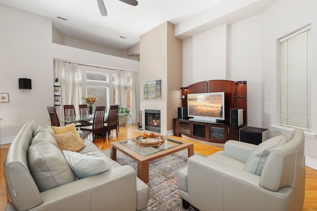 living area featuring ceiling fan, baseboards, visible vents, and wood finished floors
