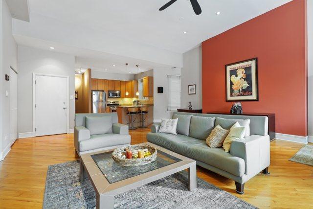 living room with ceiling fan, baseboards, and light wood-style floors
