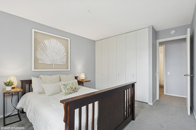 bedroom with light colored carpet and baseboards