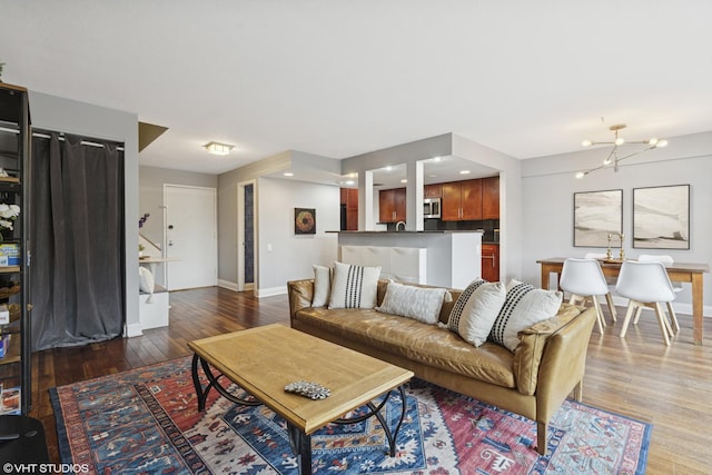 living area featuring wood finished floors, baseboards, a chandelier, and recessed lighting