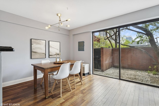 dining space featuring a chandelier, hardwood / wood-style floors, and baseboards
