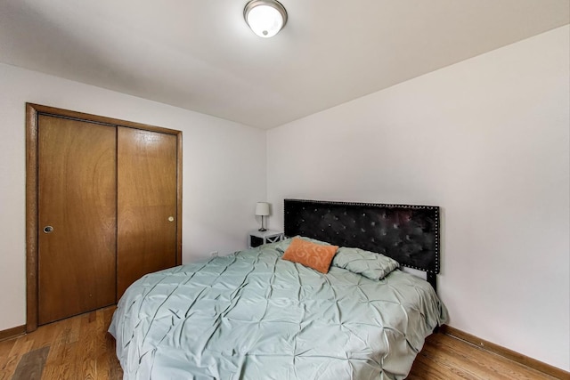 bedroom with baseboards, a closet, and wood finished floors