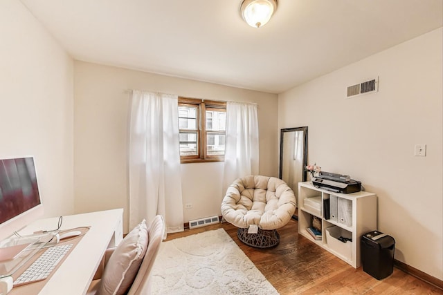 living area with visible vents and wood finished floors