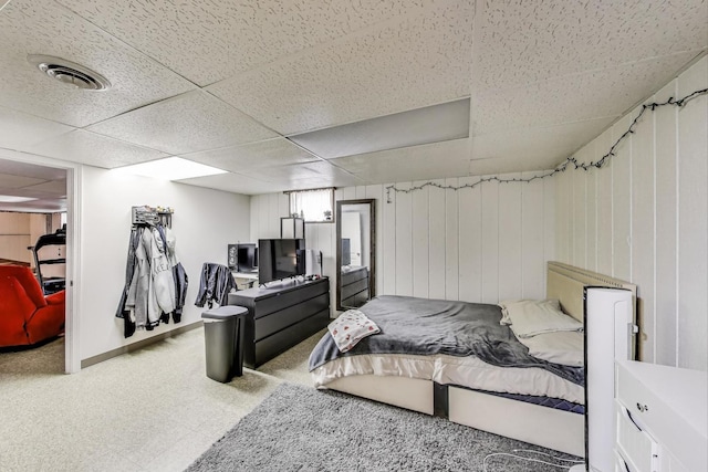 bedroom featuring a drop ceiling, visible vents, carpet floors, and a walk in closet