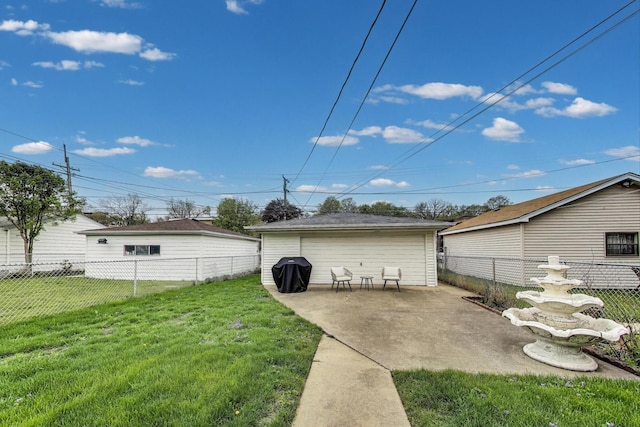 view of yard with a fenced backyard, a detached garage, and a patio