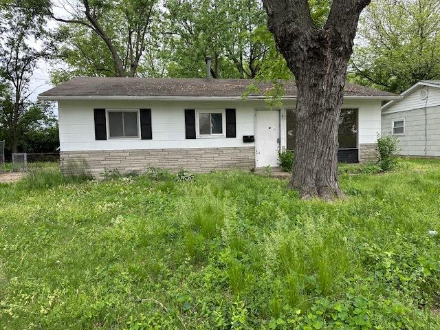 111 Saint Thomas Ln, Cahokia, IL 62206 - view of front facade with fence, a shingled roof, and stone siding