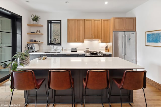2645 N Mozart St, Chicago, IL 60647 - kitchen with stainless steel appliances, a sink, light countertops, a breakfast bar area, and recessed lighting