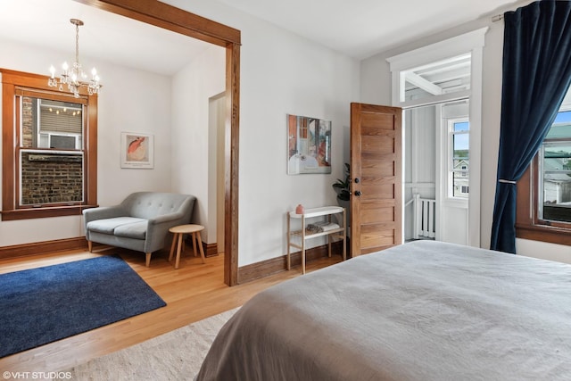 2645 N Mozart St, Chicago, IL 60647 - bedroom with a chandelier, wood finished floors, radiator, and baseboards