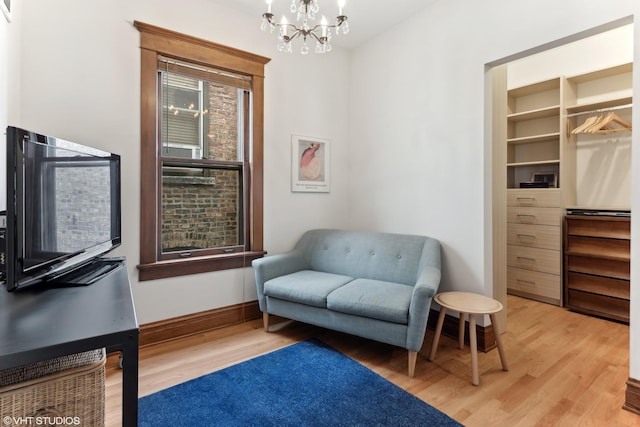 2645 N Mozart St, Chicago, IL 60647 - sitting room with light wood-style flooring, a chandelier, and baseboards