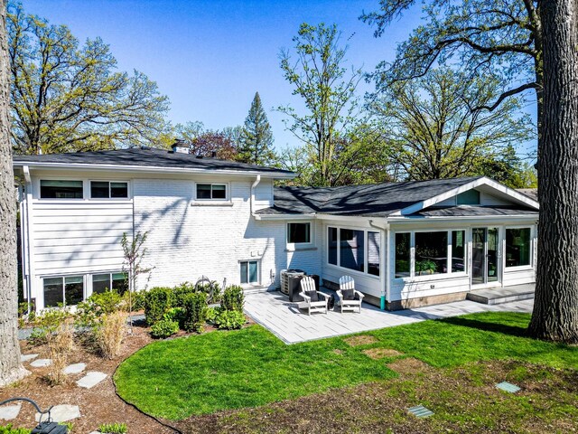 1232 Blackthorn Ln, Deerfield, IL 60015 - back of property with brick siding, a lawn, a chimney, cooling unit, and a sunroom
