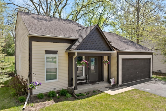 view of front facade with asphalt driveway, an attached garage, a shingled roof, and a front yard