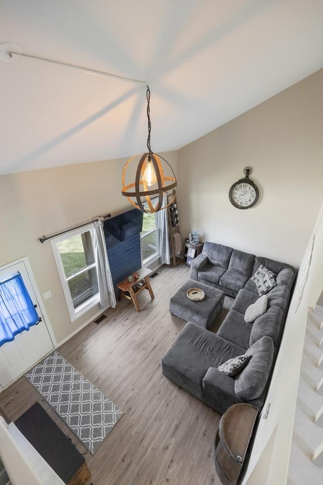 living room with wood finished floors, stairs, and a chandelier