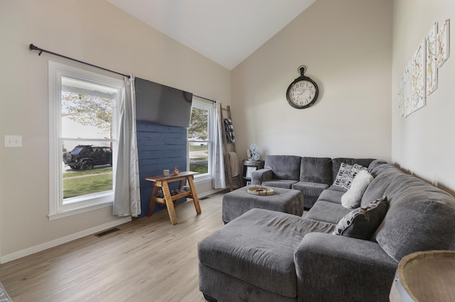 living room featuring light wood-type flooring, baseboards, and high vaulted ceiling