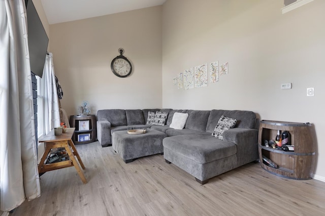 living room featuring light wood-style flooring and vaulted ceiling