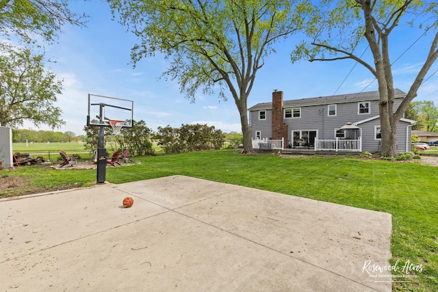 view of basketball court featuring a yard and basketball court