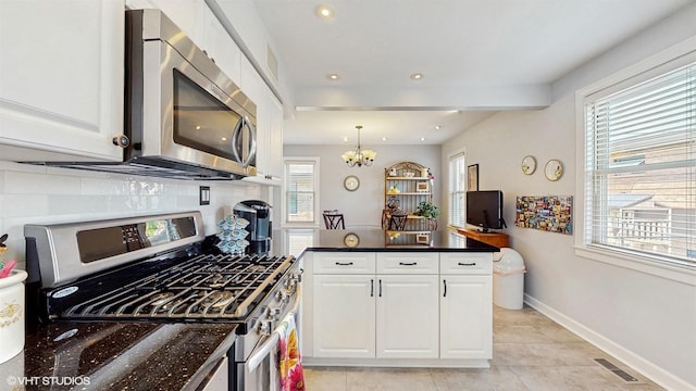 kitchen with stainless steel appliances, white cabinetry, a chandelier, a peninsula, and decorative backsplash
