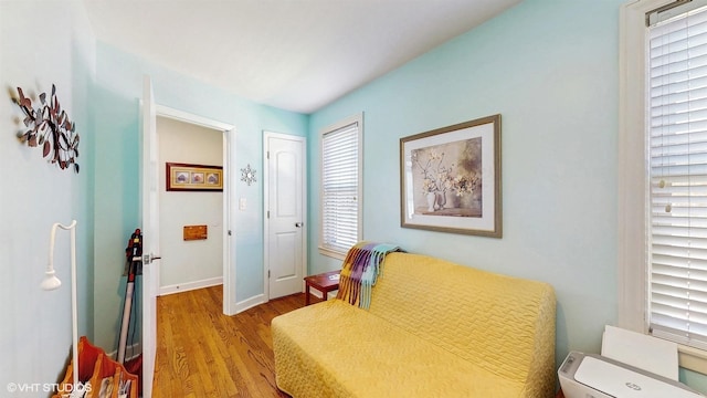 sitting room featuring wood finished floors, plenty of natural light, and baseboards